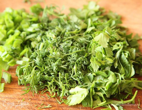 Айсберг (можно взять любой листовой салат) рвем крупными кусками, добавляем в салатник. Нарезаем зелень, тоже отправляем в салатник.