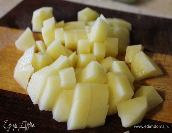 Картофель режем кубиком и кладем в бульон. Варим картофель 15 минут, потом добавляем рис.