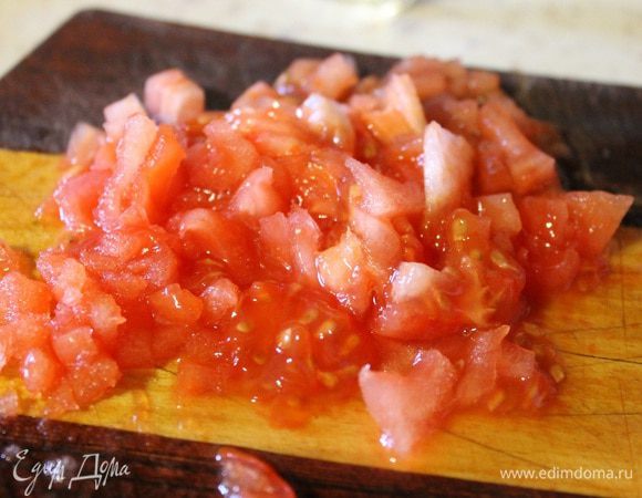 С помидора снять кожицу, нарезать мелким кубиком и добавить к зажарке. Тушить все вместе 5 минут, в конце добавить томатную пасту.
