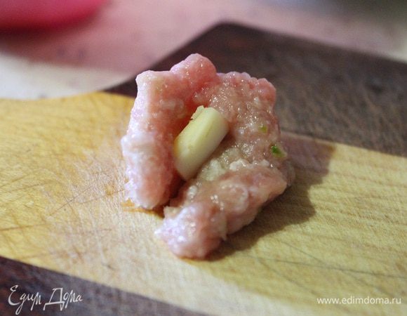 Берем небольшое количество фарша, примерно с грецкий орех. Слегка расплющиваем его на ладошке, в середину кладем два кубика сыра и аккуратно его прячем в фарше. У меня получилось 8 таких фрикаделек.