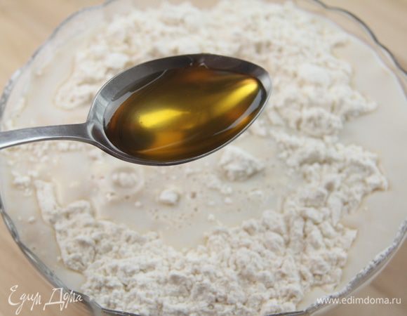 В муку влить молочно-дрожжевую смесь, добавить ложку мёда.