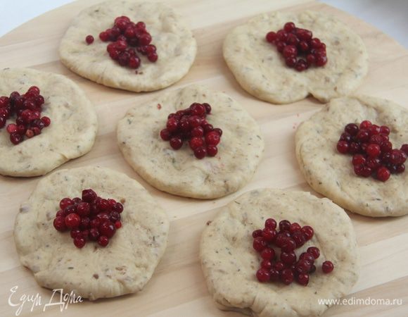 Каждый колобок сплющить и на получившуюся лепёшку выложить по чайной ложке брусники.