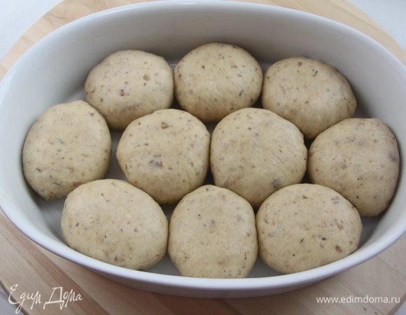 Соединить края и защипать, сформировав булочку с начинкой внутри. Булочки уложить в смазанную сливочным маслом огнеупорную форму. Оставить на полчаса в тёплом месте.