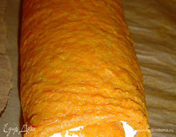 И сворачиваем с помощью пергамента в рулет, а затем отправляем его на пару часов в холодильник.