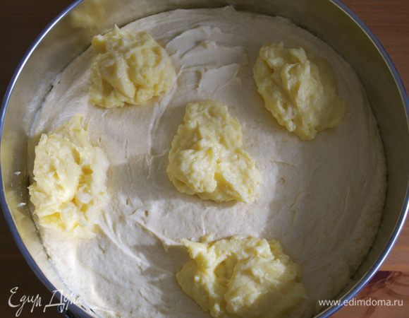 А теперь, практически, в произвольном порядке, выложить ложками оба крема на поверхность бисквит. Сначала белый крем...