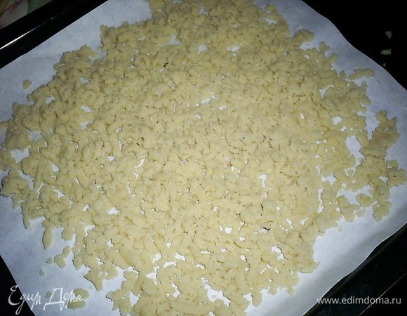 Натираем тесто на крупной терке сразу на противень с пергаментом. Равномерно распределяем.