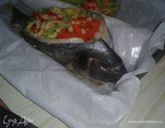 Рыбу развернуть и поставить на противень на лодочку из промасленной пергаментной бумаги. Начинку выложить в рыбу и сбрызнуть олив. маслом.