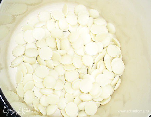 Пришло время для ванильного ганаша. Шоколад поломать на мелкие кусочки и слегка подогреть. Поместить его в глубокую емкость, подходящую для взбивания погружным блендером. Именно так мы и будем готовить ганаш.