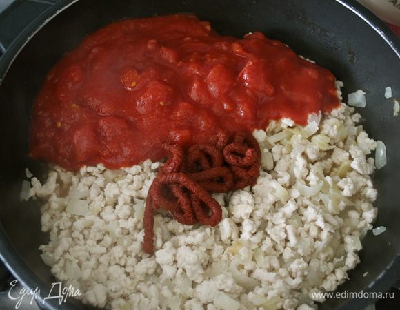 Добавить немного измельченные томаты, томат-пасту, базилик, орегано. Немного посолить и поперчить. Довести до кипения и готовить минут 5, помешивая.