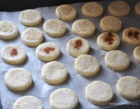 Масло размягчить в миске и растереть с творогом, добавить сахар и разрыхлитель. Перемешать и добавить муку. Замесить мягкое тесто, завернуть в пищевую пленку и на час в холодильник. Вытащить, раскатать, вырезать кружки. Посыпать сахаром, кунжутом и корицей. Выпекать при 180 градусах около 30 минут.