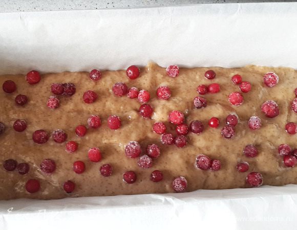 Вылить тесто в форму, устланную пергаментом. Сверху высыпать бруснику (не размораживать). Выпекать около 40 минут при 190°С.