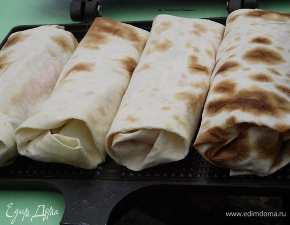 Запекать на умеренно прогретых углях по 3-4 минуты с каждой стороны. Можно воспользоваться сеткой, но лучше подойдет закрытая форма для мангала. Таким образом лаваш сохранит сок овощей внутри, а сверху будет с хрустящей корочкой.