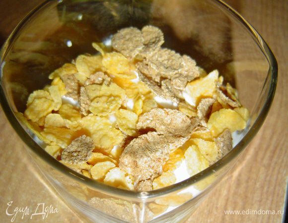 Сверху кладем кукурузные хлопья, на них кубики киви, а затем снова творожно-сливочную массу.