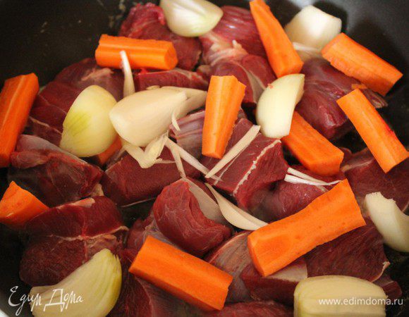 Поместить в сотейник 25 г сливочного масла и 2 ст.л. оливкового. Когда смесь начнет слегка дымиться, положить нарезанные крупными кубиками куски телятины, моркови и репчатого лука.