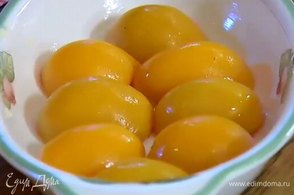 Частью натертого масла смазать дно и бока жаропрочной керамической формы, выложить персики срезами вниз.