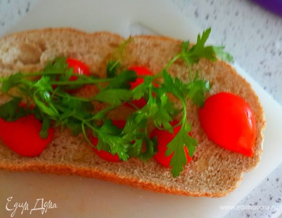 Разрезать пополам помидоры черри( но  это не принципиально. Можно и другие мелкие помидорки). Положить на хлеб. Сверху петрушку.