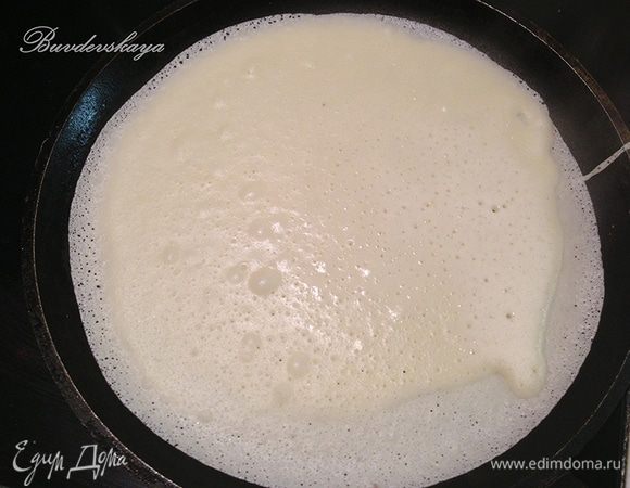 4. Разогреть растительное масло на блинной сковороде. При помощи половника выливать тесто на сковороду тонким слоем и выпекать блины. Когда кромка начнет золотиться, перевернуть блин. Складывать блины в стопку, смазывая их поверхность небольшим количеством сливочного масла (можно растопить для удобства), чтобы они не слипались. Дать блинам немного остыть.