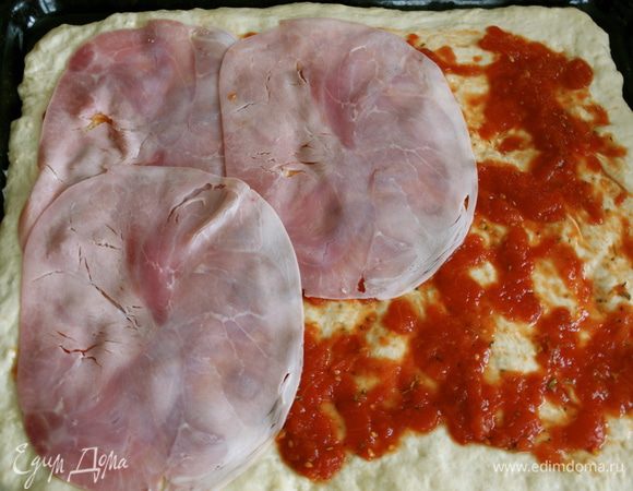 Сверху уложить тонко нарезанные ломтики вареной ветчины...