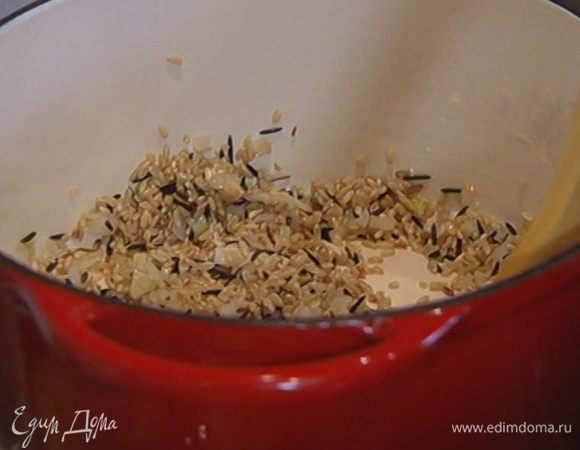 Всыпать к луку рис, перемешать и немного прогреть.