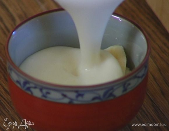 Залить бананы йогуртовой массой, сверху украсить оставшимися кружками банана и миндальными лепестками.