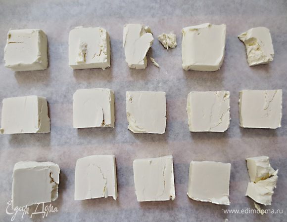 Масло разрезать на кусочки и выложить на бумагу для выпечки ( масло должно быть замороженным)