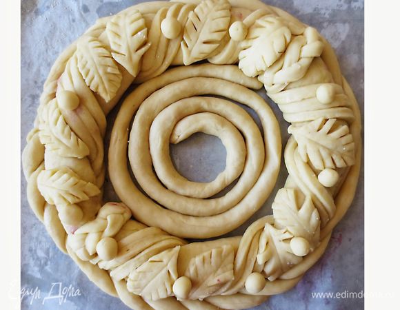 Готовое тесто разделить на 2 части. Из одной части раскатать прямоугольный пласт 60 на 15 см, выложить начинку, слепить края и свернуть в кольцо.