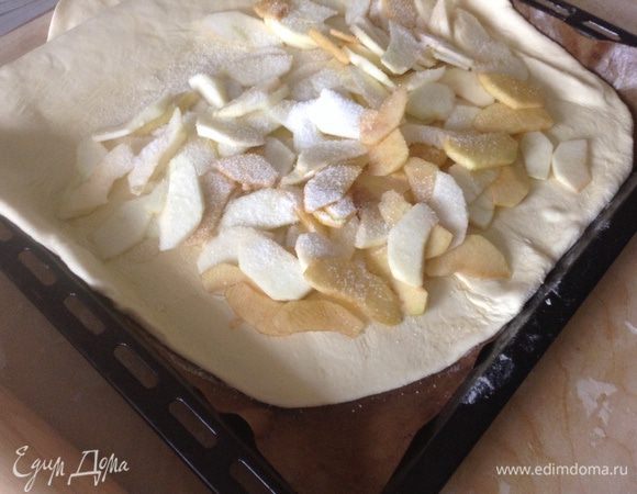 На половину лепешки равномерно положить яблоки и посыпать сахаром.