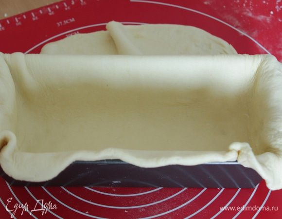 Смазать форму для выпечки.
Тесто раскатать в тонкую лепёшку по величине вашей формы так, чтобы уложив в неё тесто, оставались свисать края.