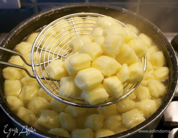 Как только вода в кастрюле закипит, посолить и положить отвариваться ньокки. На это потребуется совсем мало времени... Домашние ньокки варятся минуты 2... Как только они всплывут на поверхность, достать с помощью шумовки и выложить в глубокое блюдо.