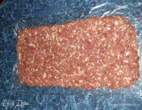 На пищевой пленке равномерное разложить весь фарш прямоугольником.