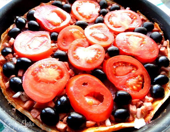 Оливки разделить пополам и щедро выложить на пиццу.