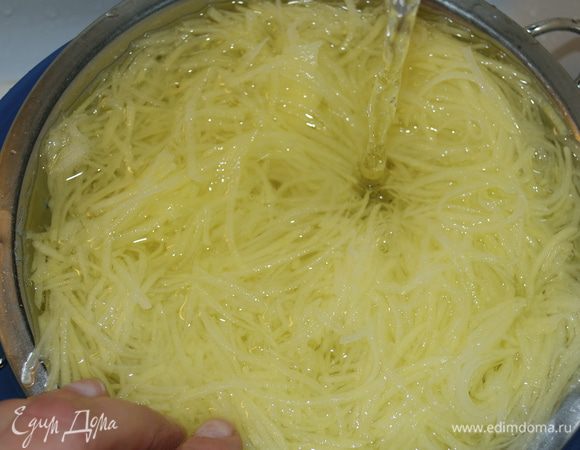 Выложить картофель в дуршлаг и поместить его в миску более крупного размере. Поставить под проточную воду и промывать, двигая картошку немного рукой, пока вода не станет прозрачной (уйдет лишний крахмал). 