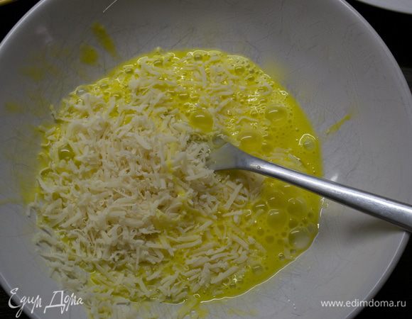 Яйцо слегка взбить вилкой и добавить тертый пармезан. Перемешать.