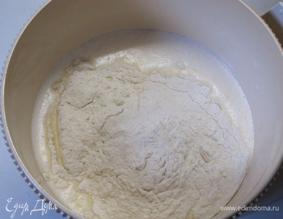 В теплое молоко добавить взбитые с сахаром и солью яйца. Всыпать половину муки, сухие  дрожжи, размешать.