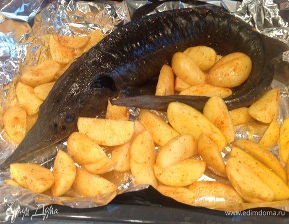 Картофель порезать на четвертинки, смешать со специями. Выложить рыбу и картофель на противень с фольгой.