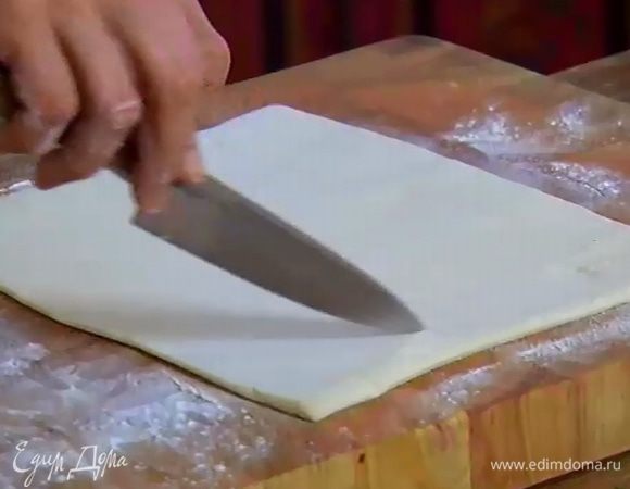 Рабочую поверхность присыпать оставшейся мукой и раскатать один пласт теста не слишком тонко. Отступая от края на 1–2 см, надрезать тесто ножом, не прорезая до конца, так чтобы получилась рамка.
