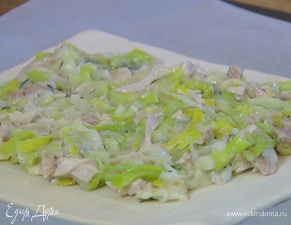 Противень выстелить бумагой для выпечки, поместить на нее раскатанное тесто и равномерно разложить начинку, оставив свободными надрезанные края.