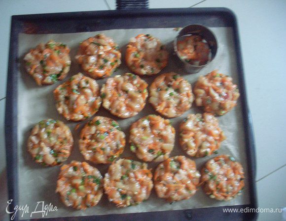 С помощью стальной формочки для салата выложить на тефлоновый лист кружочки из фарша.