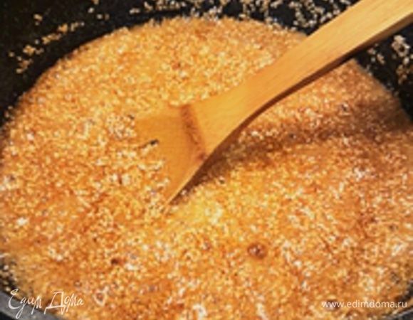 Добавить кунжутные семечки (или смело можно заменить на 3 стакана любых порубленных обжаренных орехов) и хорошо перемешать. Продолжать готовить, постоянно помешивая пока сахар не начнет карамелизоваться - то есть коричневеть. Должен появиться характерный запах. Это может занять около 20 минут, в зависимости от температуры.