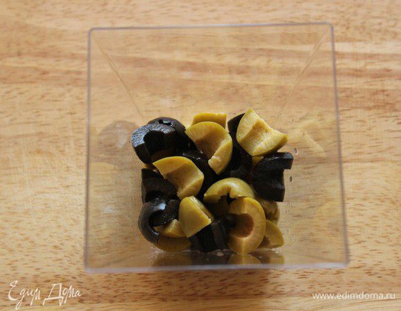 На дно стакана положить оливки и маслины.