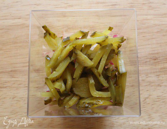 Третий слой - соленый огурец соломкой.