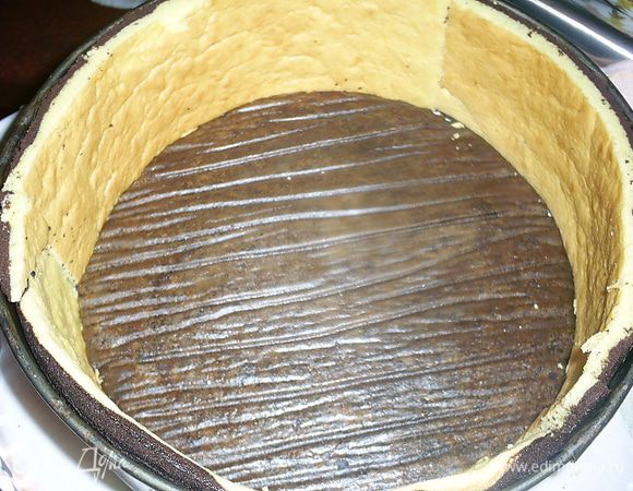 В форму кладем один шоколадный бисквит наверх той стороной, которая была на пергаменте. Устанавливаем бортики из бисквита.