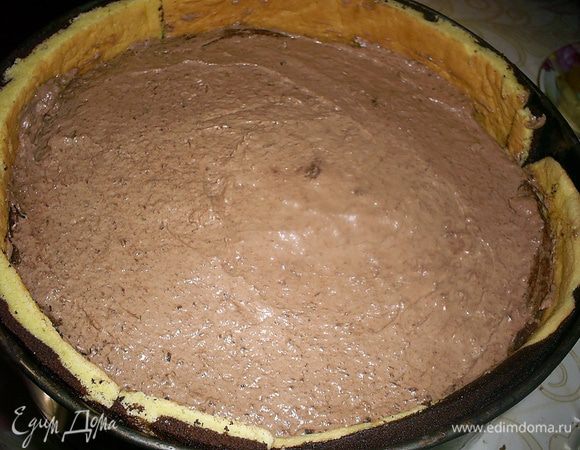 Затем выкладываем сверху мусс, оставив немного для сглаживания верха торта. Затем кладем второй шоколадный бисквит. А сверху выравниваем поверхность муссом. Отправляем торт в холодильник минимум на час.