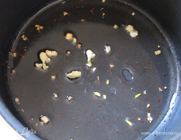 Нагреть масло в кастрюле. Добавить измельченный чеснок и шафран. Жарить 2 минуты.
