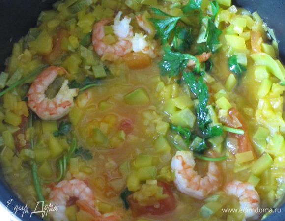 Когда помидоры станут развариваться, добавить отварные креветки и веточки петрушки. Кастрюлю накрыть крышкой и оставить на маленьком огне на 5 минут.