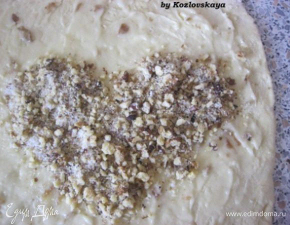 Приготовить начинку. Смешать сахар ( у меня сахарная пудра), сливочное масло, нарезанный  мелко изюм. 
Раскатать тесто примерно размером 30х25 см. Выложить начинку на всей поверхности. Сверху посыпать молотыми грецкими орехами. Разровнять.