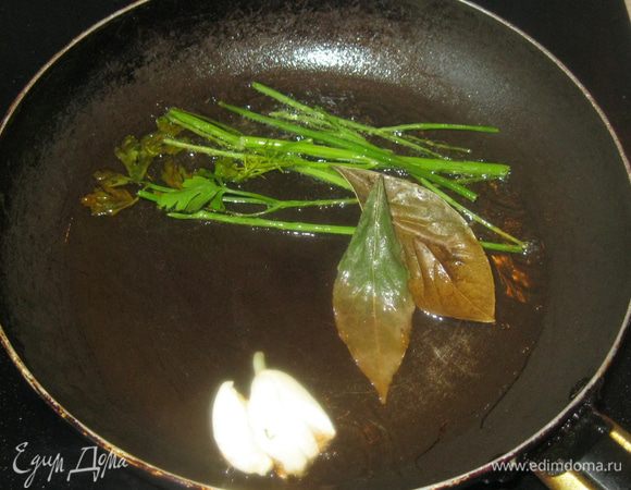 Сначала нужно подготовить масло. В, разогретом на сковородке, растительном масле я обжарил раздавленный зубчик чеснока, листики лаврушки и веточки зелени. Это не только придаст маслу аромат, но и очистит его от ненужных примесей. 