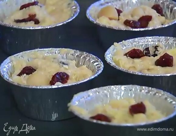 Формочки для маффинов смазать оставшимся сливочным маслом, разложить в них тесто, заполняя на 2/3 объема, сверху украсить оставшимися орехами и вишней.