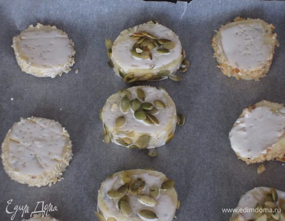 Каждую часть нарезать на кружочки  толщиной 1 см. Выложить печенье на противень, смазать сливками. Выпекать в разогретой до 180 °С духовке 20 минут. Остудить на решётке.