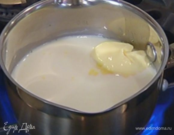 Молоко влить в небольшую кастрюлю, добавить 50 г предварительно размягченного сливочного масла и прогреть, чтобы масло растопилось.